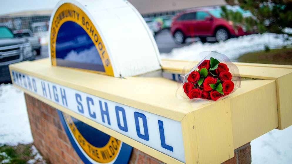 A bouquet of roses sits on a sign outside of Oxford High School on the day after the school shooting in Oxford, Mich. Wednesday, Dec. 1, 2021. A 15-year-old sophomore opened fire at the school, killing several students and wounding multiple other people, including a teacher. (Jake May/The Flint Journal via AP)