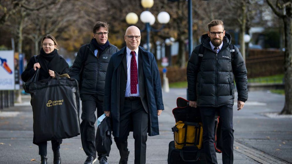 L'arrivée vendredi en début d'après-midi au Tribunal d'arrondissement de Lausanne du journaliste du Tages-Anzeiger (au centre) entouré de ses trois avocats.