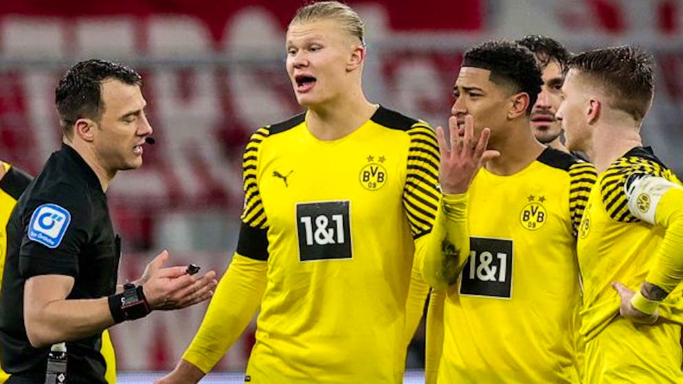 Schiedsrichter Zwayer wird von Dortmunds Spielern belagert.