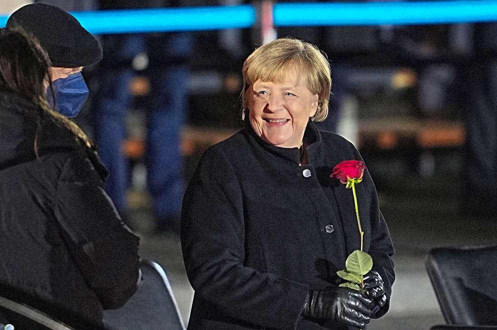 02.12.2021, Berlin : la chancelière allemande Angela Merkel (CDU) rit après avoir été remerciée par l'armée allemande, une rose à la main, à côté de son mari, Joachim Sauer. C'est par un grand coup de chapeau que la chancelière Merkel fait ses adieux à la fin de son règne de 16 ans au Bendlerblock. Elle a invité une bonne cinquantaine de ministres fédéraux de son mandat, ainsi qu'une série de compagnons de route de différents secteurs de la société. T