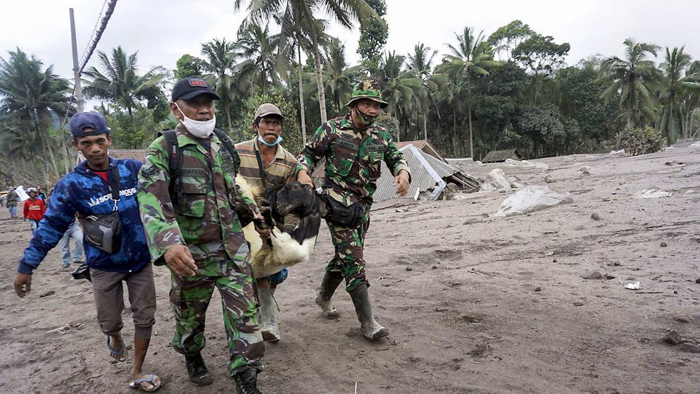 Militari allontanano la gente dai villaggi minacciati dal vulcano Semeru.