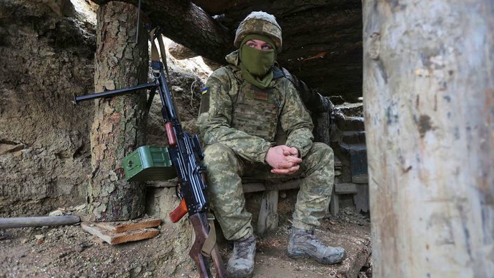 dpatopbilder - 03.12.2021, Ukraine, Debalzewe: Ein ukrainischer Soldat sitzt in einem Graben an der Trennlinie zu prorussischen Rebellen. Der ukrainische Verteidigungsminister warnte, dass Russland nächsten Monat in sein Land einmarschieren könnte. Foto: Andriy Dubchak/ap/dpa +++ dpa-Bildfunk +++