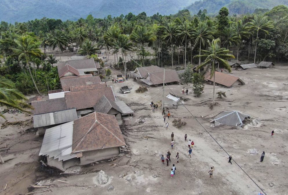 Un document photo mis à disposition par le Conseil national indonésien pour la gestion des catastrophes (BNPB) montre des villageois inspecter leur village touché par l'éruption du mont Semeru.