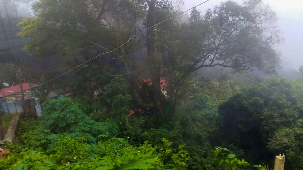 Smoke rises from fire after an army helicopter carrying India's Chief of Defense Staff Bipin Rawat crashed near Coonoor, Tamil Nadu state, India, Wednesday, Dec. 8, 2021. (Bangalore New Photos via AP)