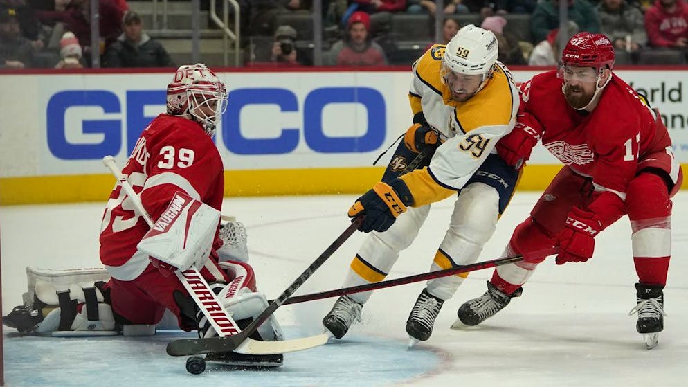 Roman Josi (al centro) aggira il portiere di Detroit Alex Nedeljkovic.