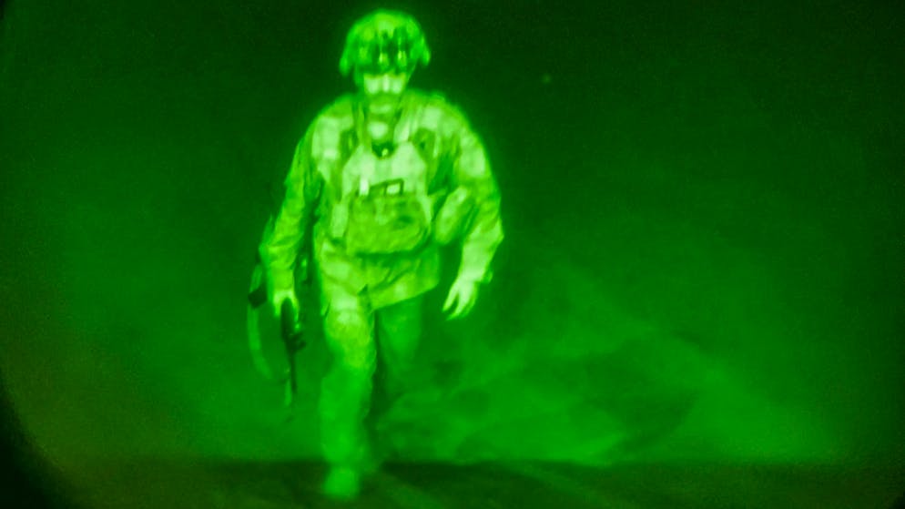 In this image made through a night vision scope and provided by U.S. Central Command, Maj. Gen. Chris Donahue, commander of the U.S. Army 82nd Airborne Division, XVIII Airborne Corps, boards a C-17 cargo plane at the Hamid Karzai International Airport in Kabul, Afghanistan, Monday, Aug. 30, 2021, as the final American service member to depart Afghanistan. (U.S. Central Command via AP)