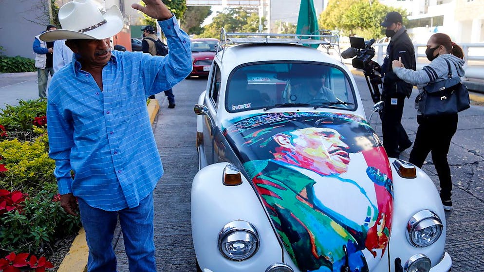 Un fan di Vicente Fernandez, con un ritratto del suo idolo sul suo 'maggiolino', davanti all'ospedale di Guadalajara dove il re della musica ranchera è deceduto.