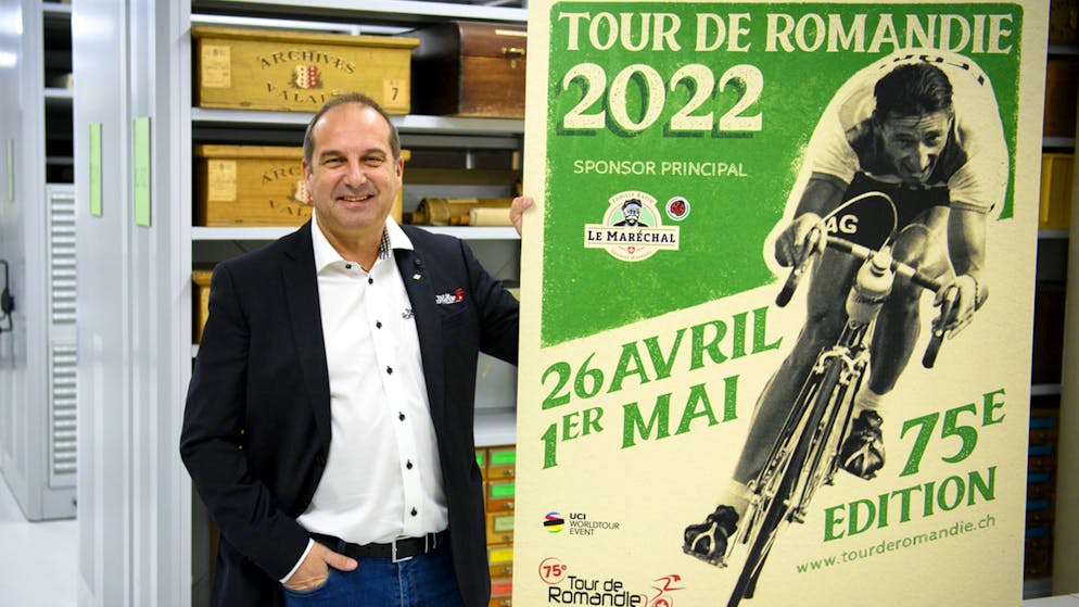 Richard Chassot, directeur du Tour de Romandie marche avec l'affiche du TDR 2022 dans les couloirs des archives cantonales valaisannes lors de la présentation à la presse.