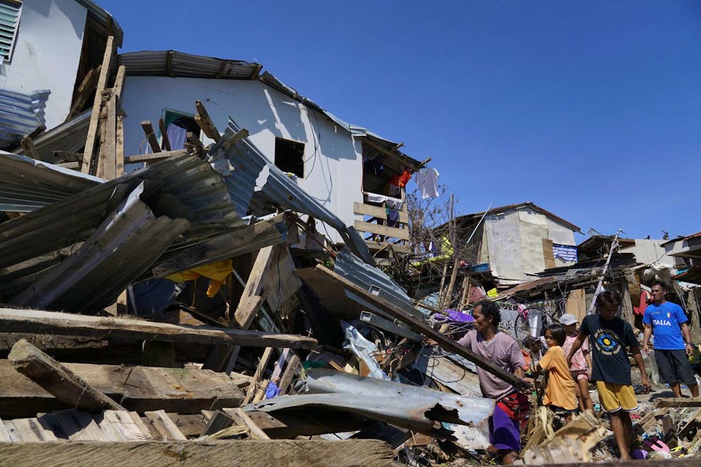 Residents salvage parts of their homes damaged due to Typhoon Rai in Talisay, Cebu province, central Philippines on Saturday, Dec. 18, 2021. The strong typhoon engulfed villages in floods that trapped residents on roofs, toppled trees and knocked out power in southern and central island provinces, where more than 300,000 villagers had fled to safety before the onslaught, officials said. (AP Photo/Jay Labra)