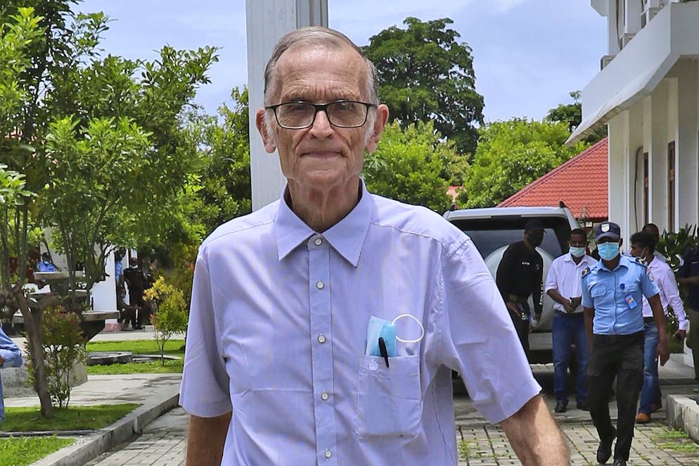 Richard Daschbach, un ancien missionnaire de Pennsylvanie, est escorté par un officier de police à son arrivée pour un procès au palais de justice d'Oecusse, au Timor oriental, le 23 février 2021. (archives)