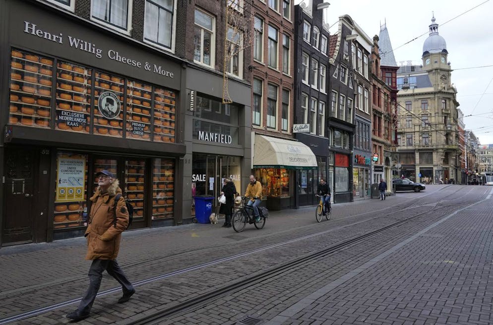 A man walks by a closed cheese store on a normally bustling shopping street in the center of Amsterdam, Monday, Dec. 20, 2021. Nations across Europe have moved to reimpose tougher measures to stem a new wave of COVID-19 infections spurred by the highly transmissible omicron variant, with the Netherlands leading the way by imposing a nationwide lockdown. All non-essential stores, bars and restaurants in the Netherlands will be closed until Jan. 14. (AP Photo/Peter Dejong)