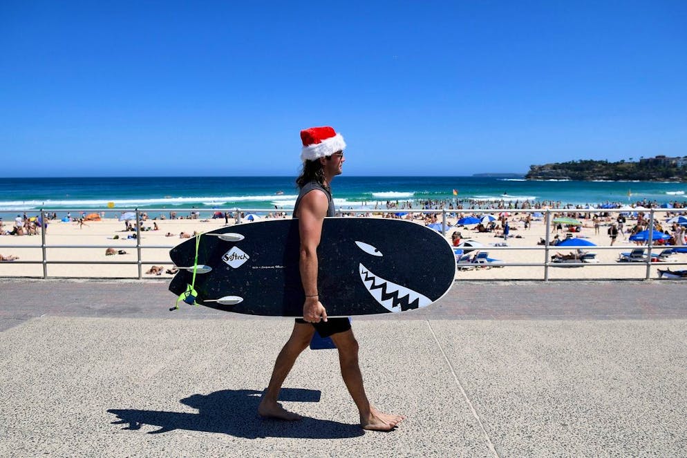 epa05687857 A surfer wearing a Santa hat spends Christmas Day on Bondi Beach in Sydney, Australia, 25 December 2016. Australia is sweltering through a heatwave with temperatures hovering around 40 degrees Celcius in many parts of the country. EPA/DAN HIMBRECHTS AUSTRALIA AND NEW ZEALAND OUT