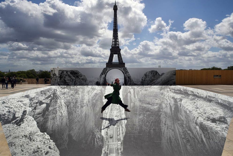 DIVERS Une femme saute sur la place du Trocadéro devant la Tour Eiffel où l'artiste et photographe français JR a posé son œuvre, à Paris, le vendredi 21 mai 2021. 