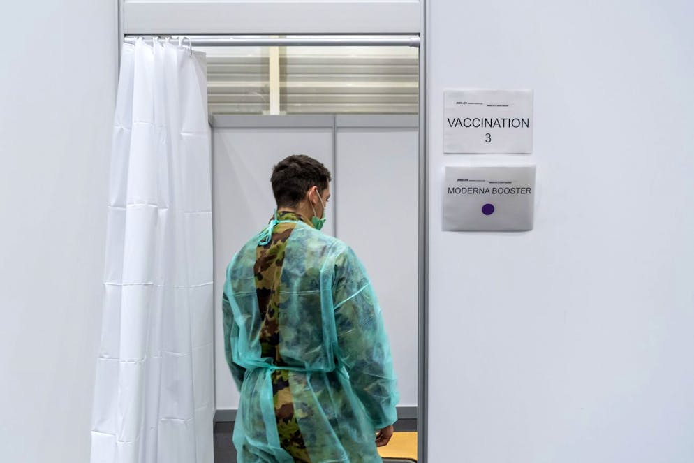 Un soldat en service long de l'école sanitaire d'Airolo prépare la cabine de vaccination avant d'administrer un rappel avec le vaccin Covid-19, au centre de vaccination de Delémont, le mardi 14 décembre 2021.