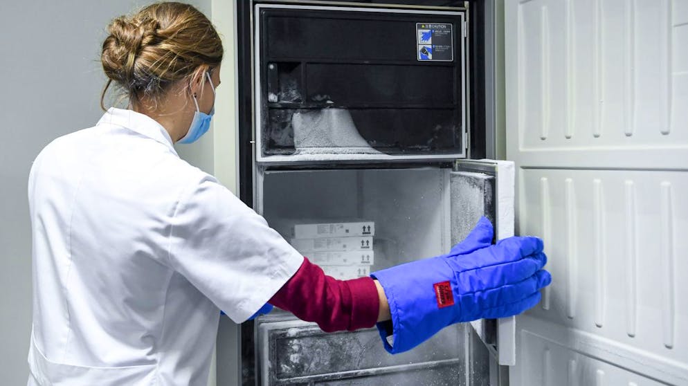 Medizinsches Personal entnimmt einem Spezialkühlschrank in einem Spital im belgischen Löwen Impfstoff von Biontech-Pfizer. (Archiv)