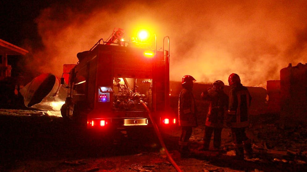 Iranische Feuerwehrleute arbeiten an einem brennenden Tankwagen mit Kraftstoff an der Islam Qala Grenze zum Iran, in der Provinz Herat, westlich von Kabul. In einer Grenzstadt im Westen Afghanistans sind Hunderte Gastankwagen einem Flammeninferno zum Opfer gefallen. Am Samstagmittag explodierte nahe der Grenze zum Iran aus noch ungeklärter Ursache ein Tankwagen und löste eine Kettenreaktion au Foto: Hamed Sarfarazi/AP/dpa