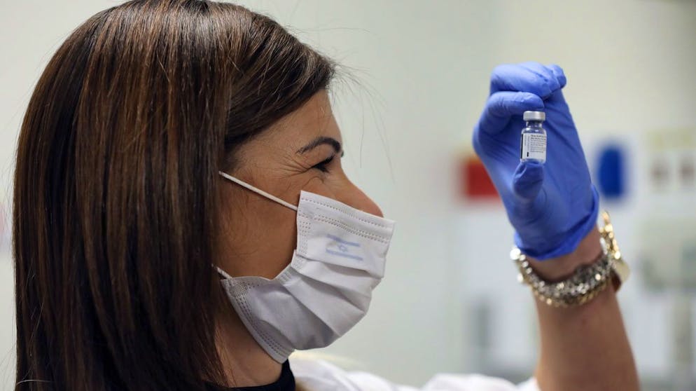 epa08895093 A senior nurse handles a vial containing five doses of 0.3ml of the Pfizer-BioNTech COVID-19 vaccine at Shaare Zedek Medical Center in Jerusalem, Israel, 20 December 2020. Israel begins a nationwide COVID-19 vaccination campaign as hundreds of thousands of vaccines are delivered to hospitals across the country. First, the medical staff will be vaccinated and then people from high potential risk groups and the elderly population. Authorities hope to vaccinate as many people as possible. EPA/ABIR SULTAN