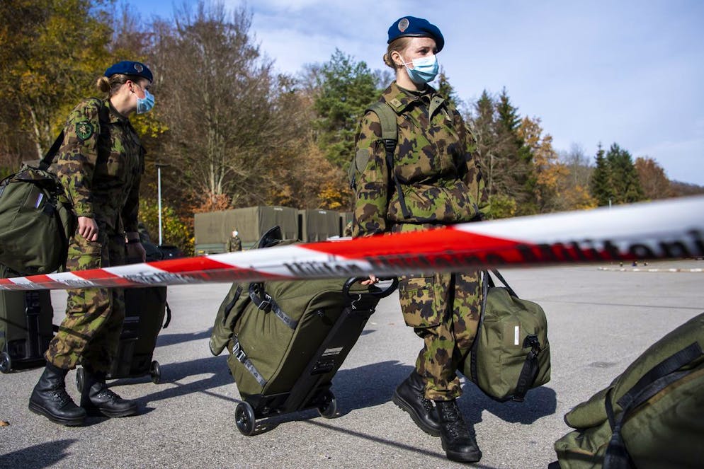 Deux femmes soldats de la compagnie sanitaire 1 arrivent lors de la mobilisation afin d'intervenir dans le systeme des soins en Suisse romande lors de la crise du Coronavirus (Covid-19) le dimanche 8 novembre 2020 a la Caserne de Moudon. Des le debut de semaine, les miliatires dechargeront le systeme de sante du canton de Geneve dans le domaine du transport et des soins de base apportes aux patients du Covid-19. (KEYSTONE/Jean-Christophe Bott)