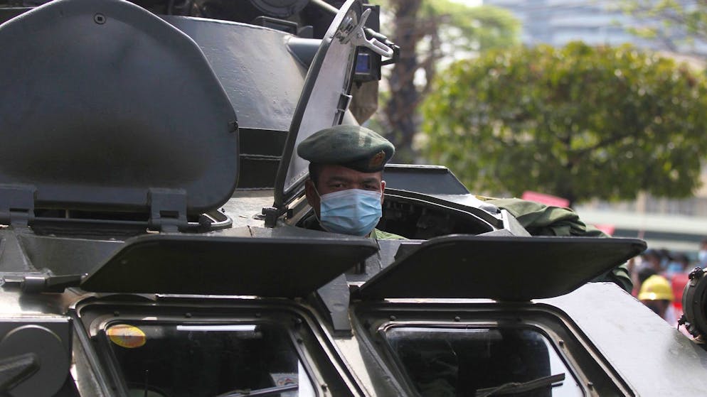 Ein Soldat schaut in Rangun aus einem gepanzerten Militärfahrzeug heraus, das vor dem Gebäude der Zentralbank steht.