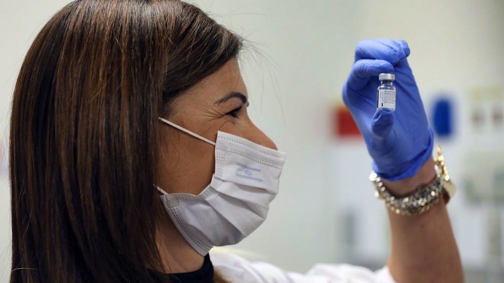 Gesundheitspersonal in Jerusalem mit einer Ampulle des Impfstoffs von Biontech/Pfizer.