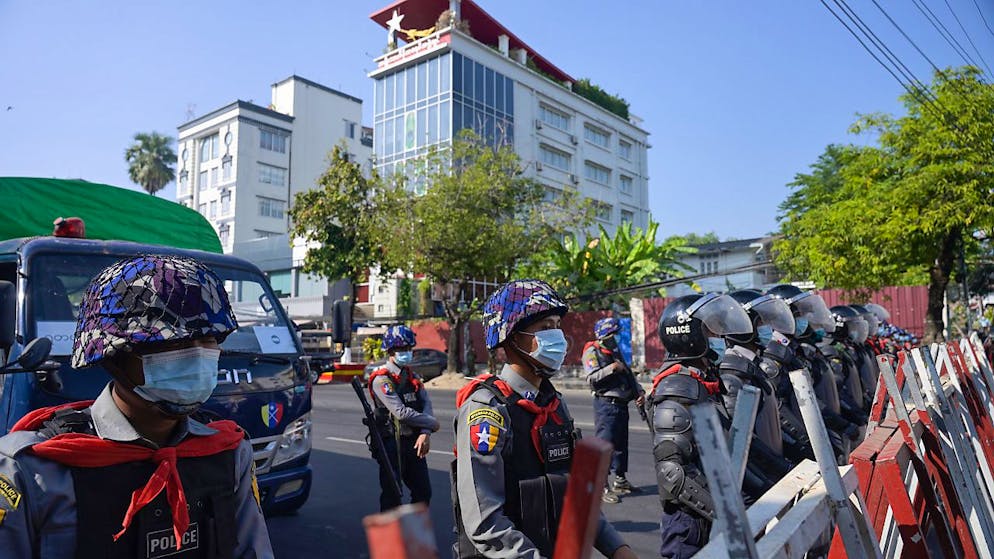 Polizisten sperren eine Straße in Rangun. Zahlreiche Menschen demonstrieren gegen den Militärputsch. Foto: Thet Htoo/ZUMA Wire/dpa