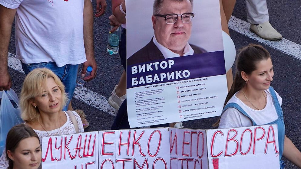 ARCHIV - Menschen laufen bei dem Marsch der Freiheit gegen Alexander Lukschenko und tragen ein Transparent mit dem Foto von Viktor Babariko. Foto: Ulf Mauder/dpa