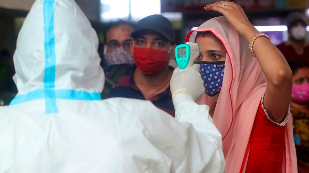 Temperaurmessung am Bahnhof Bandra in Mumbai: Zu den möglichen Erklärungen für den Rückgang gehört, dass in manchen Gegenden die Herdenimmunität bereits erreicht ist. Foto: Rafiq Maqbool/AP/dpa
