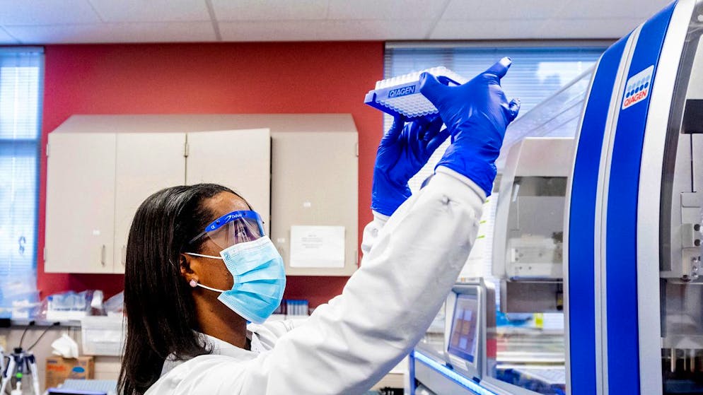Eine Laborwissenschaftlerin bearbeitet Proben von Patienten, bei denen Verdacht auf eine Corona-Infektion besteht. Foto: Noah Berger/AP/dpa