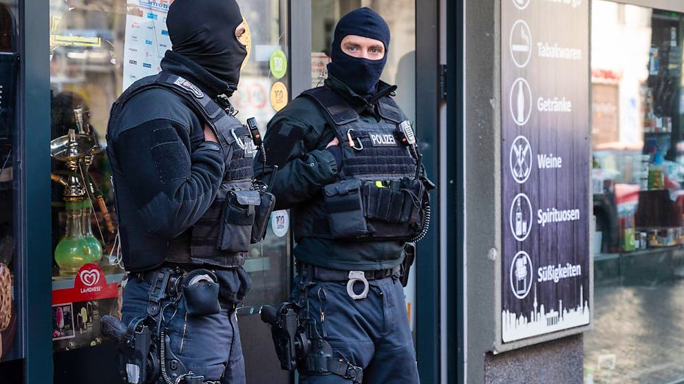 Polizisten stehen bei einer Razzia vor einem Spätkauf in Neukölln. Mit einer Großrazzia ist die Polizei am Donnerstag gegen Clankriminalität in Berlin und Umgebung vorgegangen. Foto: Christophe Gateau/dpa