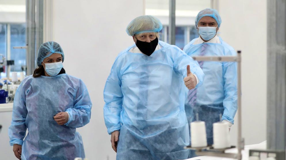 Britain's Prime Minister Boris Johnson, wearing a face mask to prevent the spread of the coronavirus, visits a PPE manufacturing facility during a visit to the north east of England, in Seaton Delaval, England, Saturday, Feb. 13, 2021. (AP Photo/Scott Heppell, Pool)