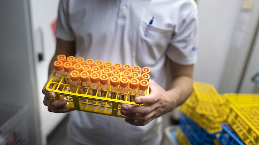 Ein Laborangestellter bringt im Zürcher Triemli-Spital Corona-Proben zur Zwischenlagerung im Kühlschrank.