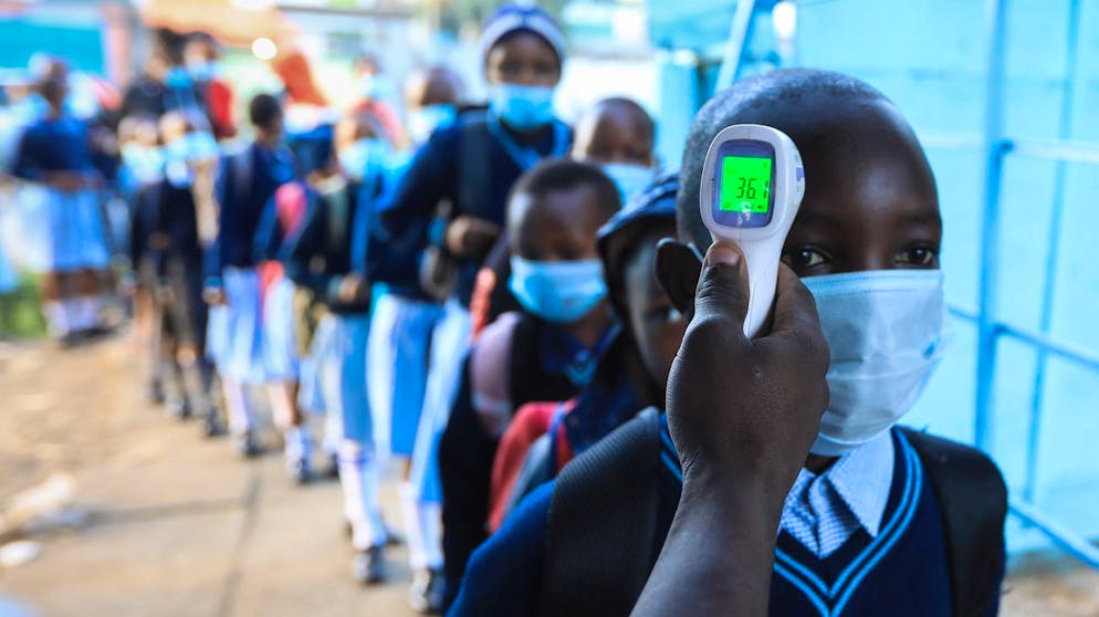 epa08918445 Pupils get their temperature taken as they head to their classrooms during the reopening of schools at the Daima Primary school in Nairobi, Kenya, 04 January 2021. Kenya reopened all its schools amid coronavirus pandemic after a nine-month closure to curb the spread of the COVID-19. The Education Minister George Magoha, called upon head teachers to set up extra classes out in open air in order to observe social distancing in the already overcrowded classrooms especially in public schools. Kenya has 23,000 public primary schools with more than 12 million pupils and more than three million students in secondary schools. EPA/Daniel Irungu