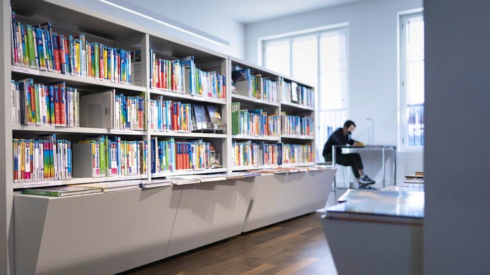 Jugendliche mit Schutzmasken sitzen an Tischen und lernen in der GGG Stadtbibliothek Basel Schmiedenhof, fotografiert am 25. November 2020 in Basel. (KEYSTONE/Gaetan Bally)