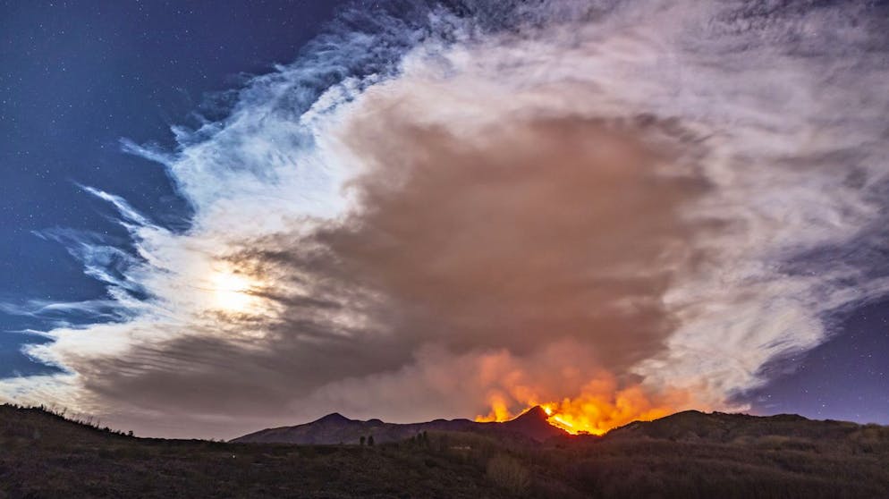 Smoke fills the sky during an eruption of Mt. Etna volcano, near Catania in Sicily, southern Italy, early Tuesday, Feb. 23, 2021. The explosion started before midnight on Monday night, provoking a huge eruption plume that rose for several kilometers from the top of Etna, as reported by The National Institute of Geophysics and Volcanology, Etneo Observatory. (AP Photo/Salvatore Allegra)