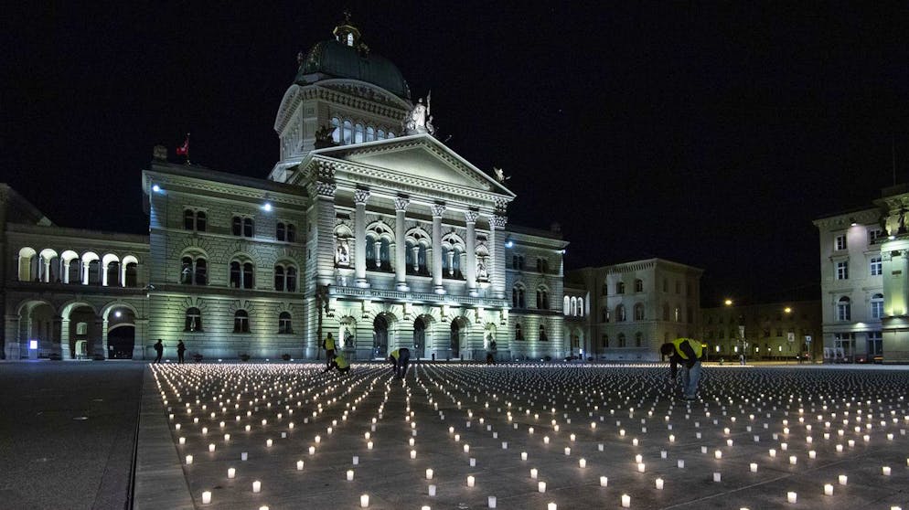 Activists light almost 9,200 candles to commemorate the people who died of Corona in Switzerland, on Sunday, February 21, 2021, on the Bundesplatz, in front of the Federal Palace, in Bern, Switzerland.  (TRAPEZOIDAL / Peter Schneider)