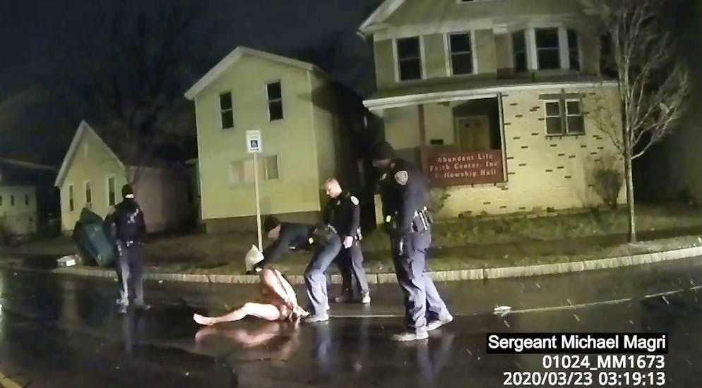 In diesem Standbild eines Videos, das mit einer Polizei-Körperkamera aufgenommen wurde, ist zu sehen, wie die Polizisten Daniel Prude eine Haube überziehen – danach drücken sie seinen Kopf zwei Minuten lang mit beiden Händen zu Boden.