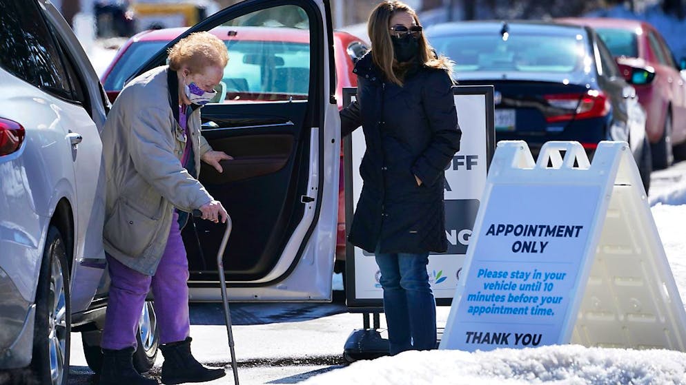 Eine ältere Frau kommt zu einer Corona-Impfstelle im Augusta Civic Center in Augusta, Maine. Foto: Robert F. Bukaty/AP/dpa