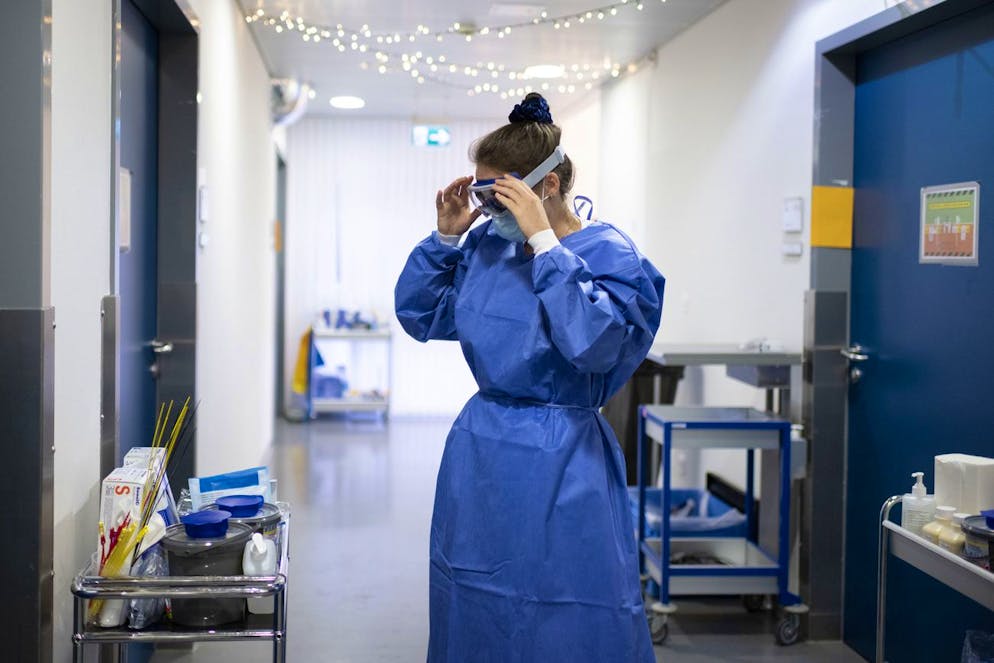 Nora Tschanz, Gruppenleiterin Pflege bekleidet sich mit der noetigen Schutzkleidung in der Isolationsstation des Universitaetsspital USZ, fotografiert am 19. November 2020 in Zuerich. (KEYSTONE/Christian Beutler)