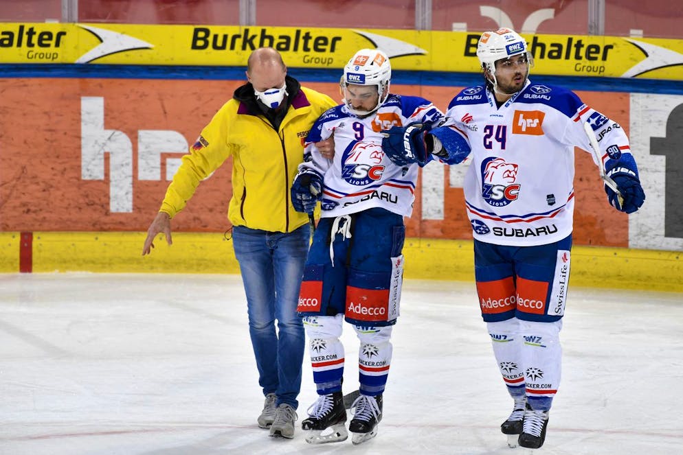 Der Zuercher Garrett Roe (USA), Mitte wird von einem Betreuer und seinem Kollegen Phil Baltisberger verletzte vom Eis gebracht, im Eishockey-Qualifikationsspiel der National League zwischen dem HC Davos und den ZSC Lions, am Dienstag, 2. Februar 2021, im Eisstadion Davos in Davos. (KEYSTONE/Juergen Staiger)