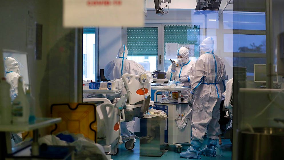 Mitarbeiter des Gesundheitswesens tragen Schutzkleidung während sie auf der Corona-Intensivstation eines Krankenhauses in Lissabon arbeiten. Foto: Armando Franca/AP/dpa