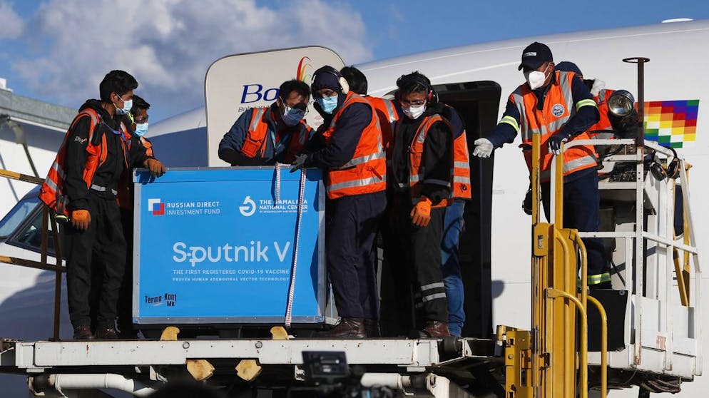 Airport employees unload the first shipment of Russia's Sputnik V COVID-19 vaccine after it arrived at the international airport in El Alto, Bolivia, Thursday, Jan. 28, 2021. (AP Photo/Juan Karita)