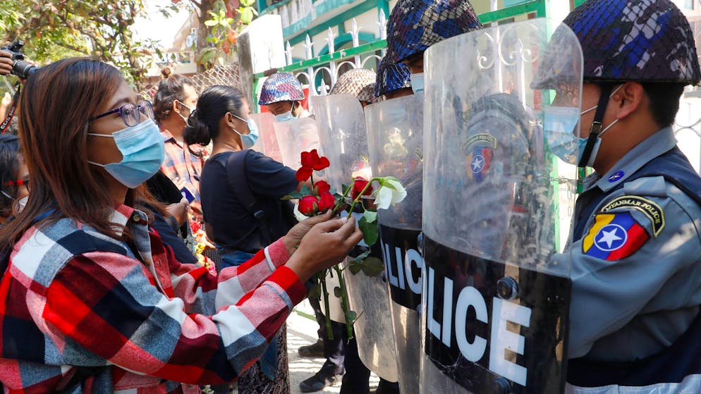 Proteste gegen den Putsch: Demonstranten in Mandaley überreichen der Polizei Rosen, das Militärregime reagiert mit Verschärfungen der Sicherheitsgesetze.