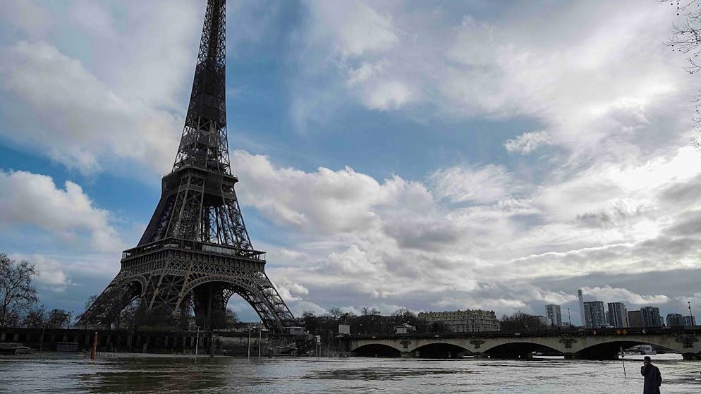 Ein Mann spaziert am überfluteten Ufer der Seine in Paris. Foto: Valery Hache/AFP/dpa