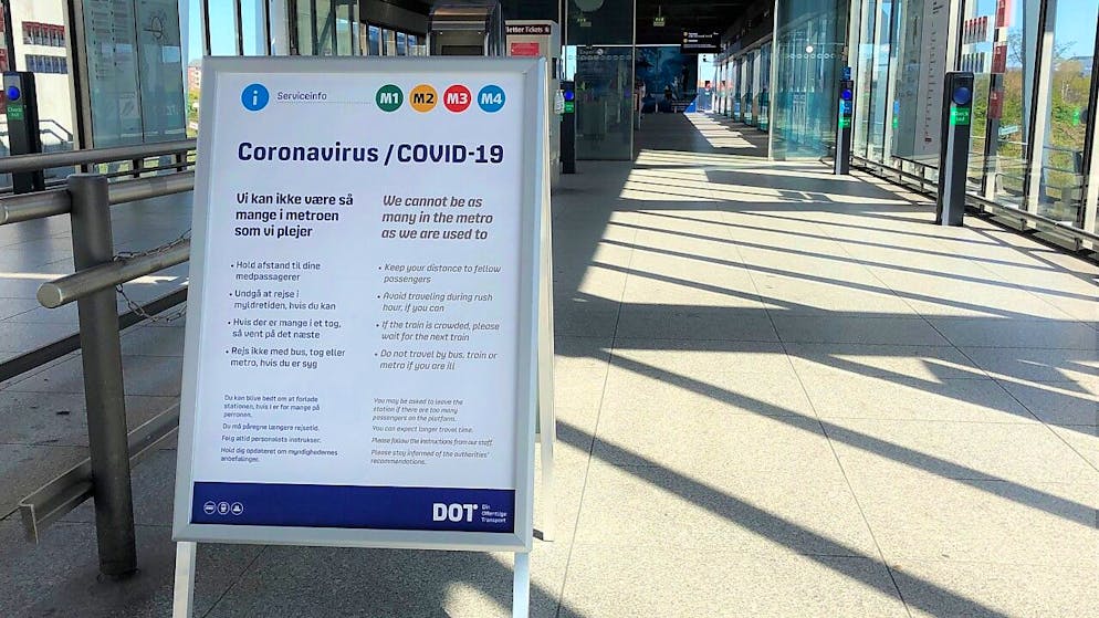 Ein Schild weist an der Metro-Station am Flughafen von Kopenhagen auf die im Nahverkehr geltenden dänischen Maßnahmen zur Eindämmung des Coronavirus hin. Foto: Steffen Trumpf/dpa