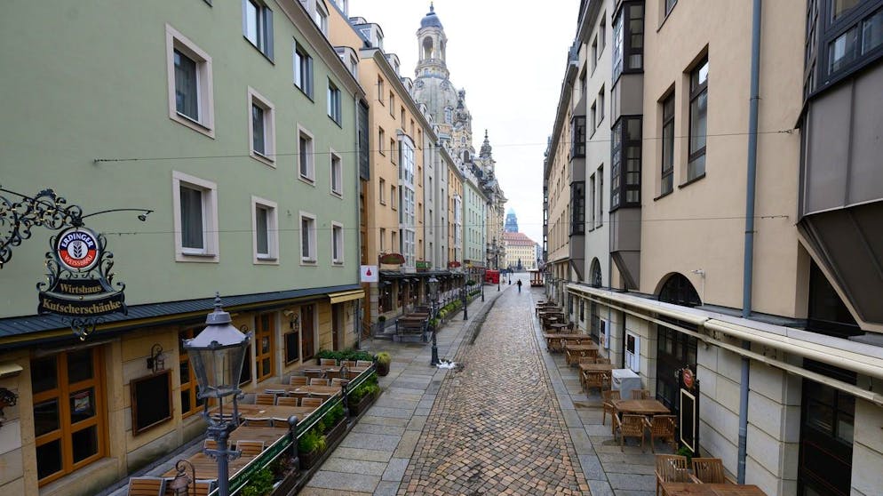02.02.2021, Sachsen, Dresden: Leere Tische und Stühle stehen vor geschlossenen Lokalen auf der Münzgasse. Im Hintergrund ist die Frauenkirche zu sehen. Sachsen erwägt erste Corona-Lockerungen im aktuellen Lockdown ab dem 15. Februar 2021. Foto: Sebastian Kahnert/dpa-Zentralbild/dpa +++ dpa-Bildfunk +++ (KEYSTONE/DPA/Sebastian Kahnert)