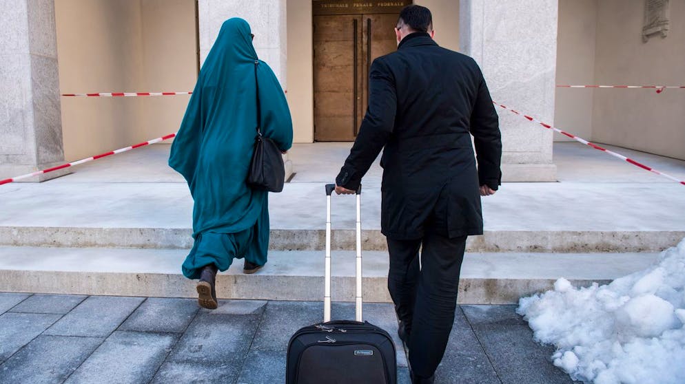 Eine mutmassliche Dschihad-Reisende, links, trifft ein vor dem Bundesstrafgericht in Bellinzona, am Freitag, 15. Dezember 2017. Die 31-jaehrige Frau wollte sich im Januar 2016 mit ihrem vierjaehrigen Sohn der Terrormiliz IS in Syrien anschliessen. Wann das Urteil fallen wird, ist noch offen.(KEYSTONE/Ti-Press/Gabriele Putzu)