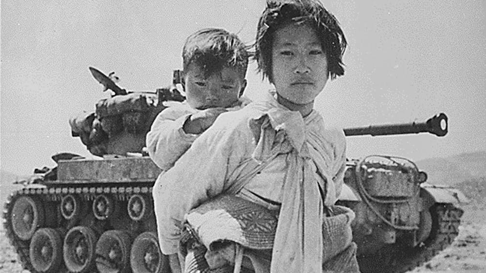 This June 9, 1951 image shows a young girl with her brother on her back as she walks past a stalled M-26 tank at Haengju, Korea. North Korean troops invaded South Korea June 25, 1950, marking the beginning of the Korean War. (KEYSTONE/EPA PHOTO/NATIONAL ARCHIVES/STR) BEST QUALITY AVAILABLE
