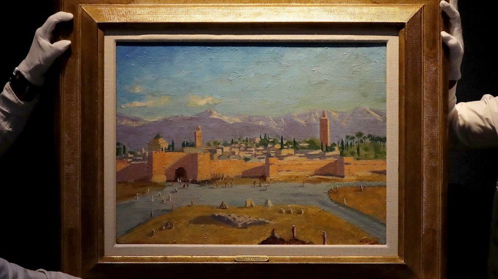 FILE - In this Wednesday, Feb. 17, 2021 file photo, Christie's employees adjust an oil on canvas painting by Sir Winston Churchill painted in Jan. 1943 called 'Tower of the Koutoubia Mosque' during an Art pre-sale photo call at Christie's auction house in London. The Moroccan landscape painted by Winston Churchill and owned by Angelina Jolie sold at auction on Monday March 1, 2021, for more than $11.5 million, smashing the previous record for a work by BritainâÄ™s World War II leader. (AP Photo/Frank Augstein, File)