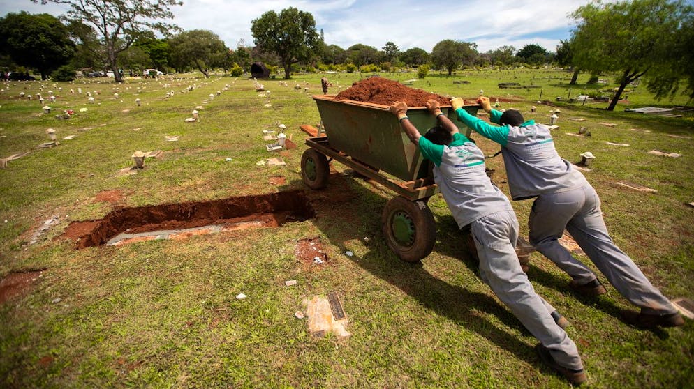 epa09091972 Workers push a container with sand, in the Campo de Esperanza cemetery, Brasilia, Brazil, 23 March 2021. Brazil borders on 300,000 deaths due to Covid-19, while the risk of shortages of essential drugs for patients with more serious conditions persists in the face of the increasing number of hospitalizations. EPA/Joedson Alves