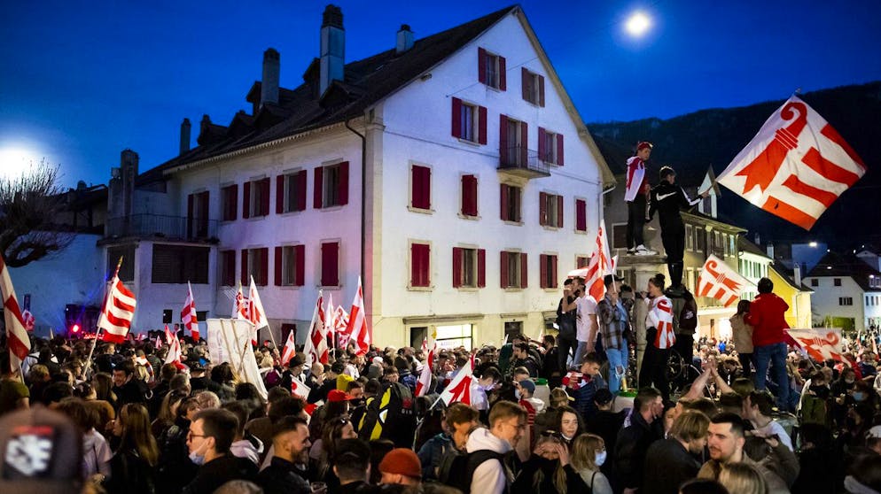 The pro-Jura people celebrate the yes in front of the Town Hall where a flag of the canton of Jura was raised after the announcement of the result of the vote this Sunday, March 28, 2021 in Moutier.  The citizens of Moutier must decide on the cantonal affiliation of their city and thus leave the canton of Bern to join that of Jura.  (KEYSTONE / Jean-Christophe Bott)